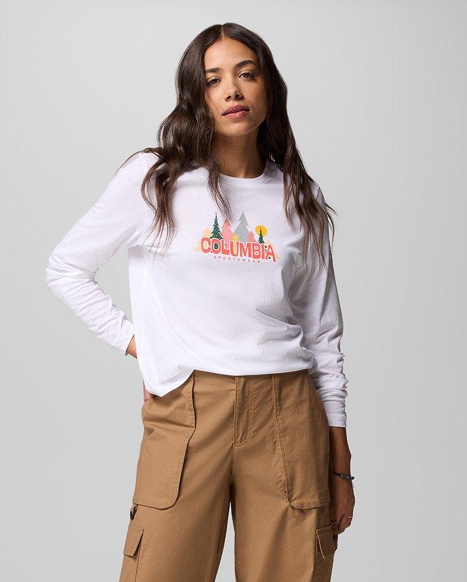 A woman wearing a white long-sleeve graphic tee.