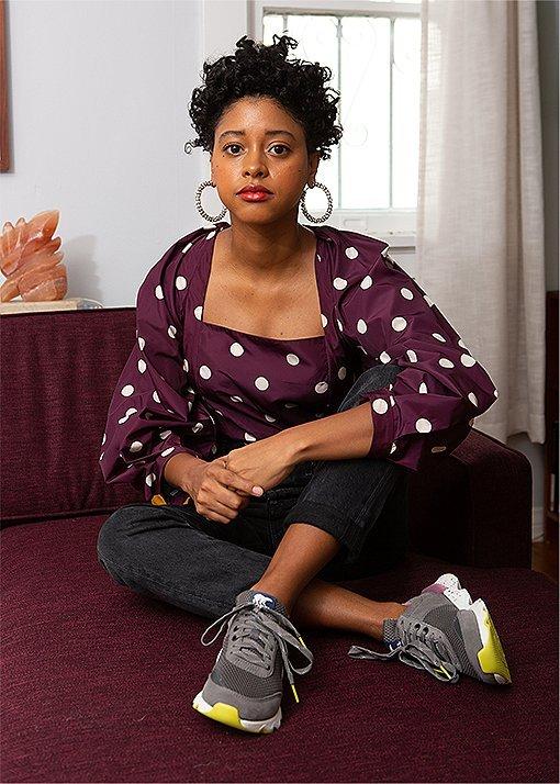 Candace Reels wearing Kinetic Lite Lace sneakers, sitting on a couch