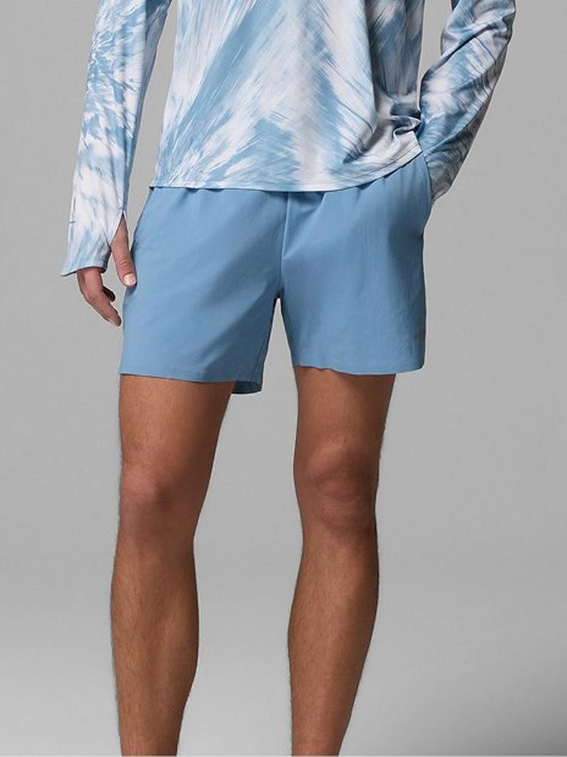 Person wearing light blue athletic shorts and a blue tie-dye long sleeve shirt.