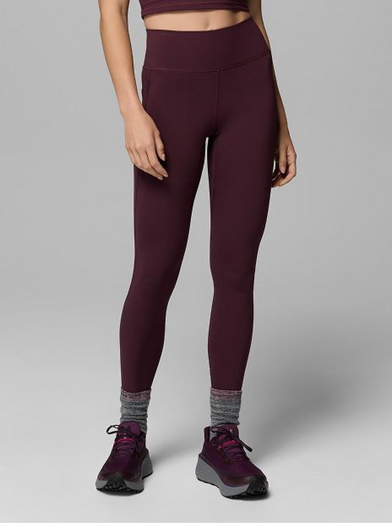 Woman wearing burgundy high-waisted athletic leggings with gray socks and matching sneakers.