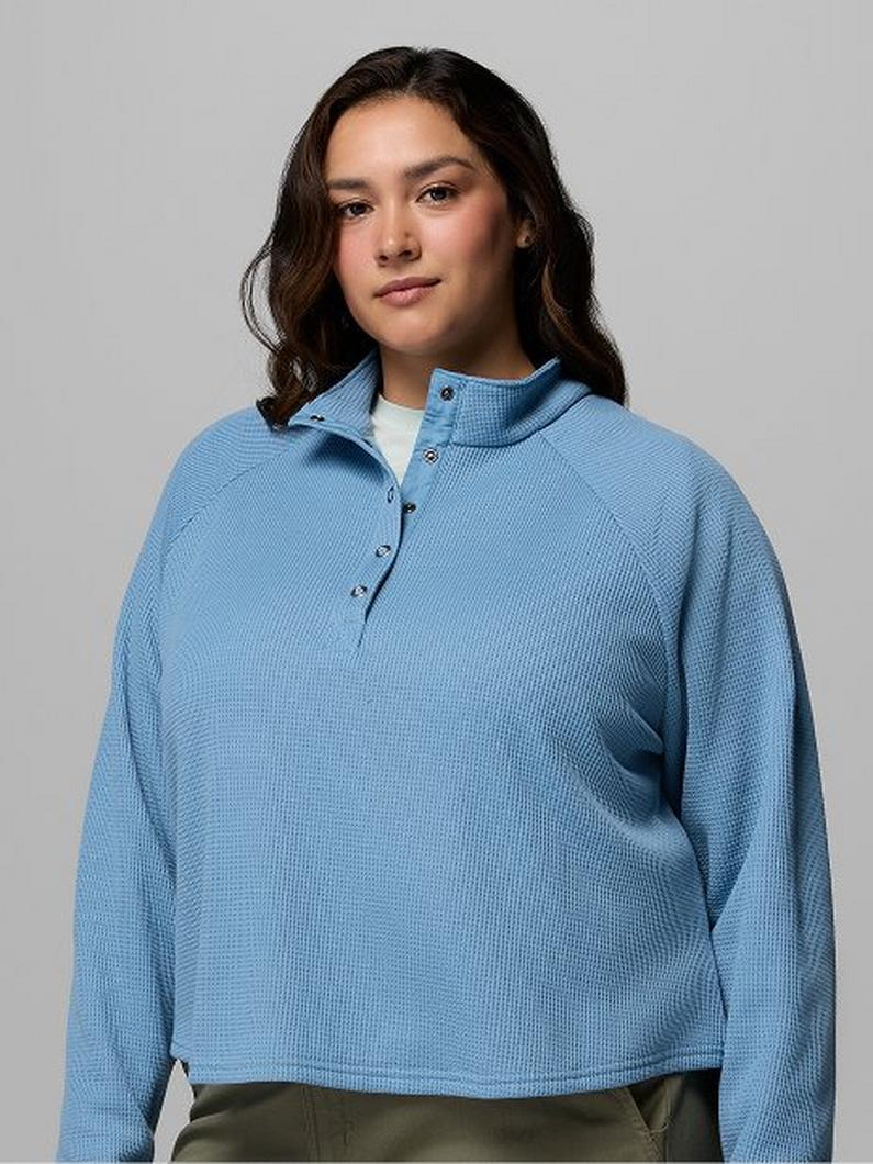 Woman wearing light blue ribbed pullover with snap button collar and relaxed fit.