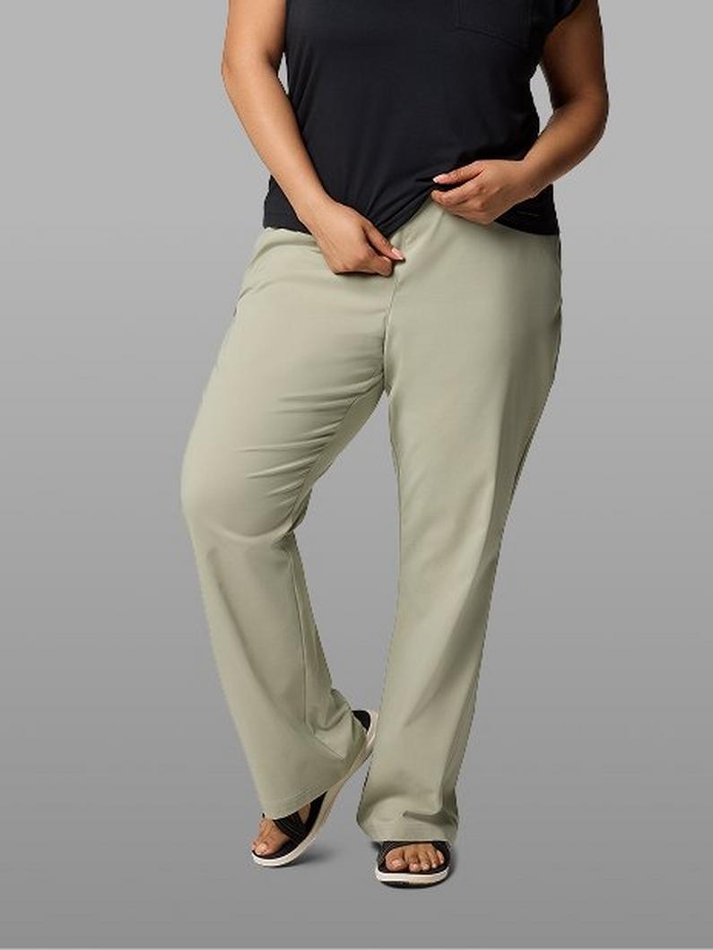 Woman wearing sage green relaxed-fit pants with black top and sandals.