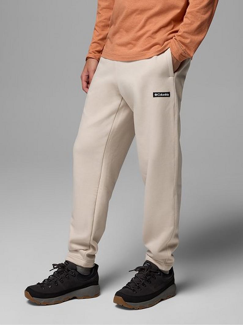 Person wearing cream-colored sweatpants with cargo pocket and coral long-sleeve top, paired with black sneakers.