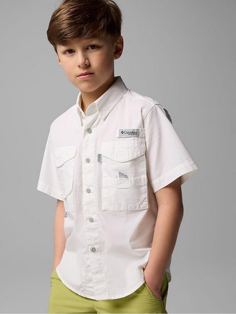 Boy wearing a white short-sleeve button-up fishing shirt with chest pockets and yellow-green shorts.