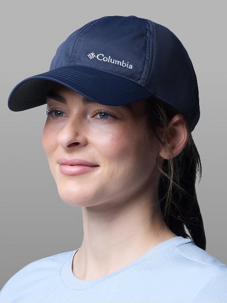 Woman wearing a navy blue baseball cap with hair pulled back in a ponytail.