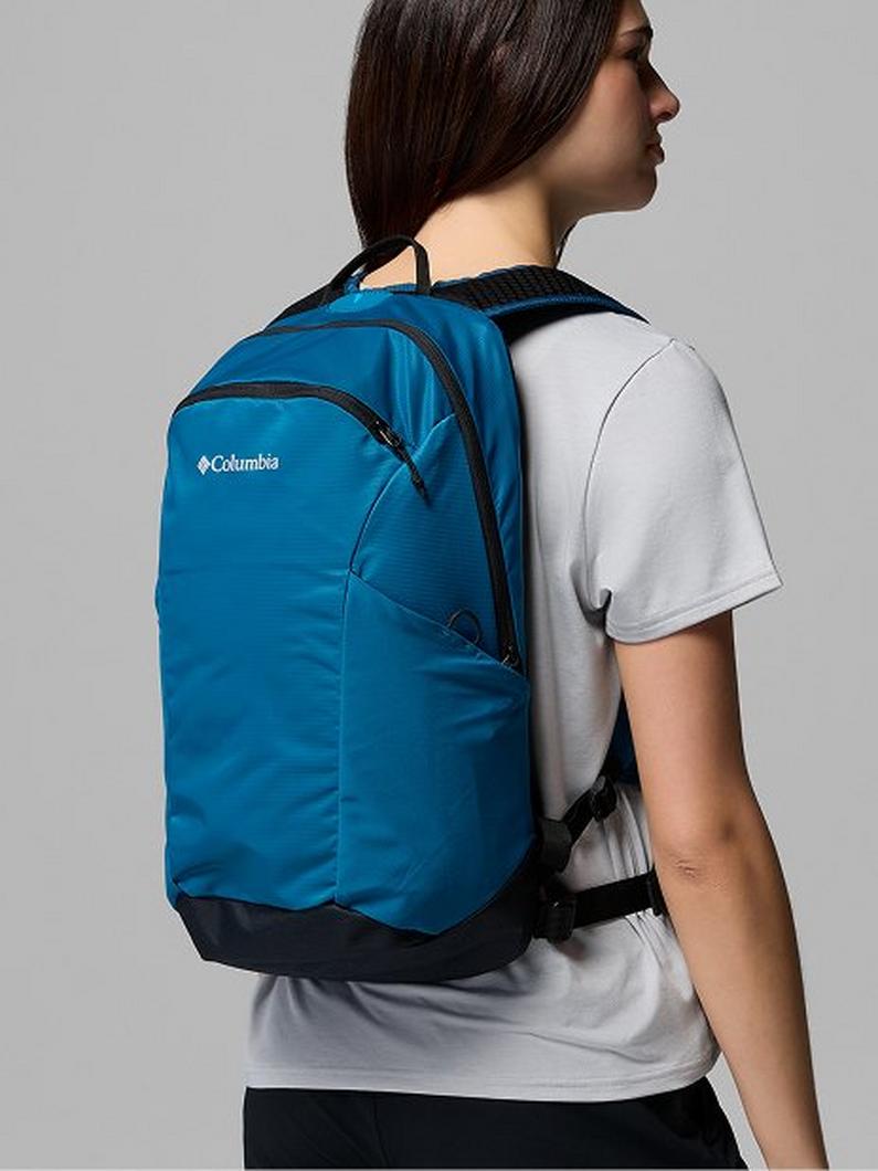Person wearing a blue backpack with black straps and bottom panel, shown from side view.