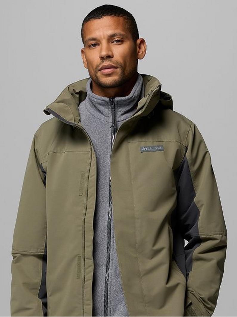 Man wearing olive green hooded jacket with black side panels over gray fleece layer.