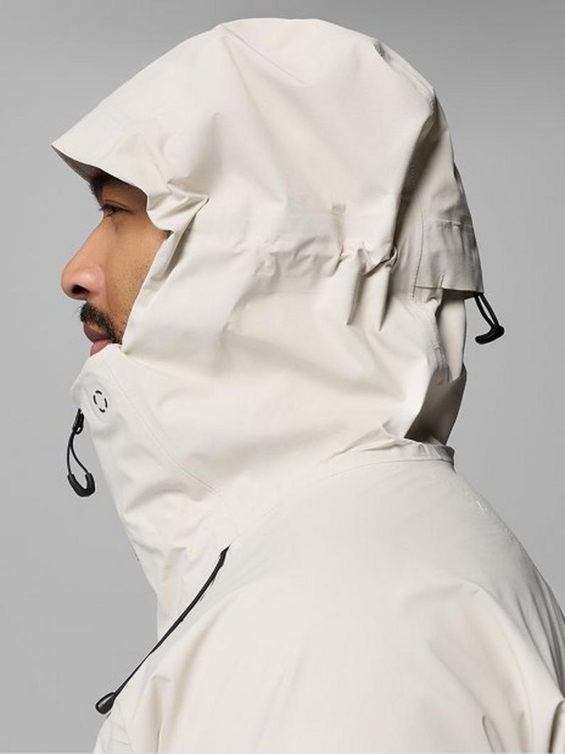 Man wearing cream hooded jacket with adjustable drawstrings, shown in profile view.