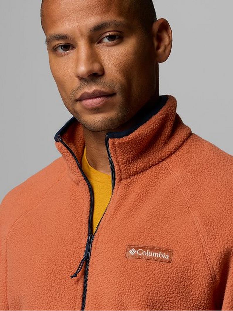 Man wearing an orange fleece quarter-zip pullover with a yellow shirt underneath.