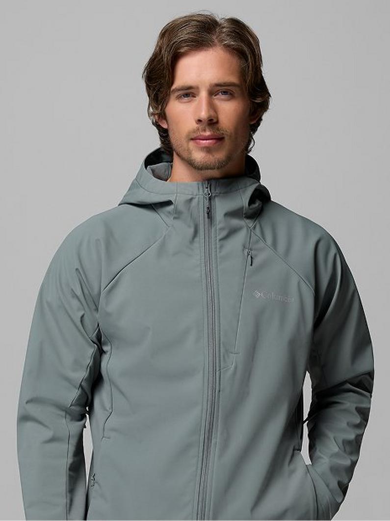 Man wearing a sage green hooded rain jacket with full front zipper and chest pocket.