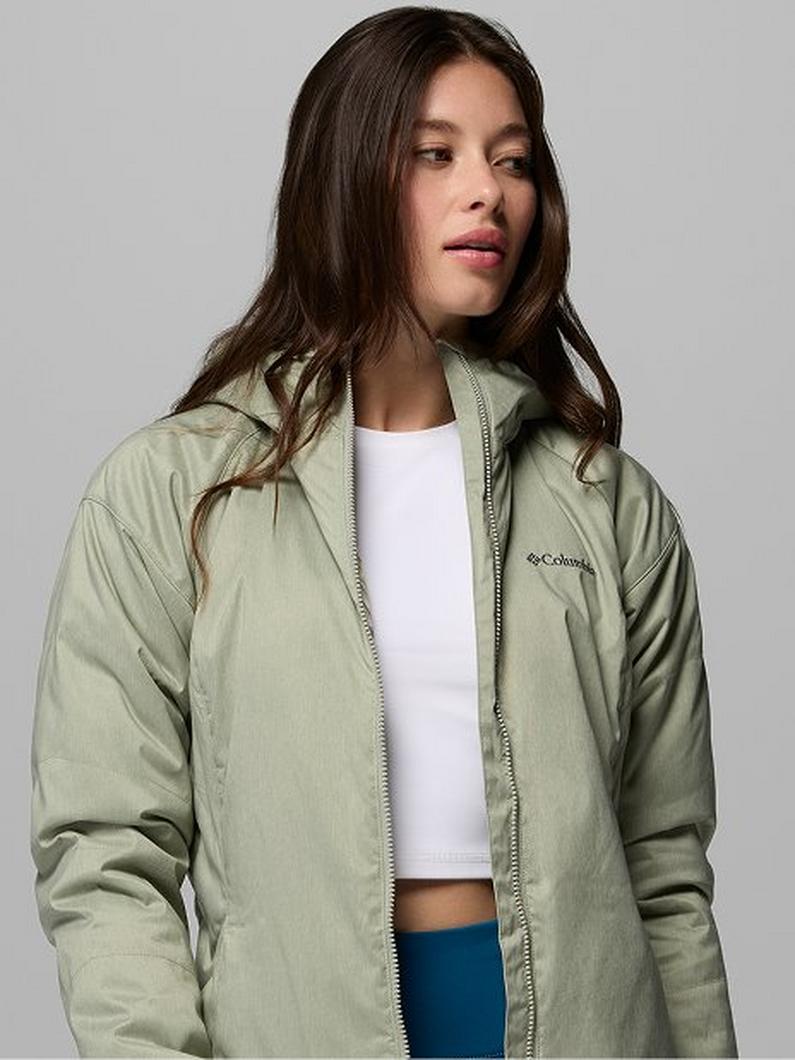 Woman wearing a light green hooded zip-up jacket over a white crop top and blue pants.