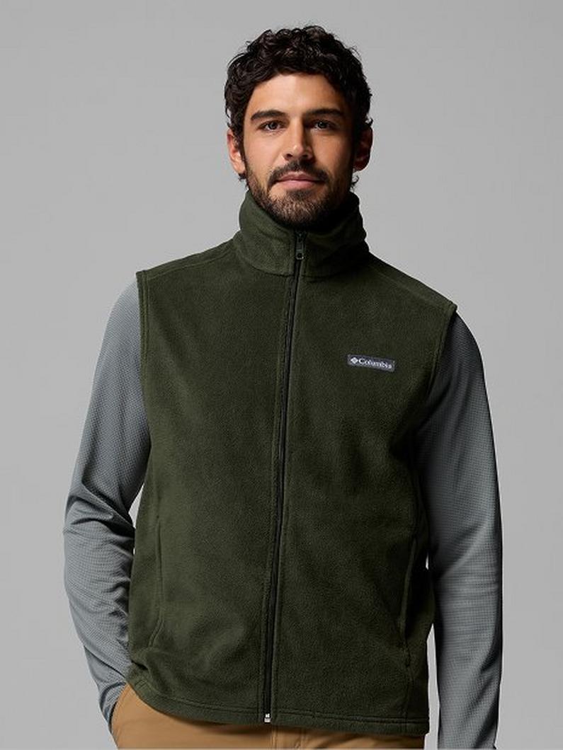 Man wearing olive green fleece vest with gray long sleeves and khaki pants.