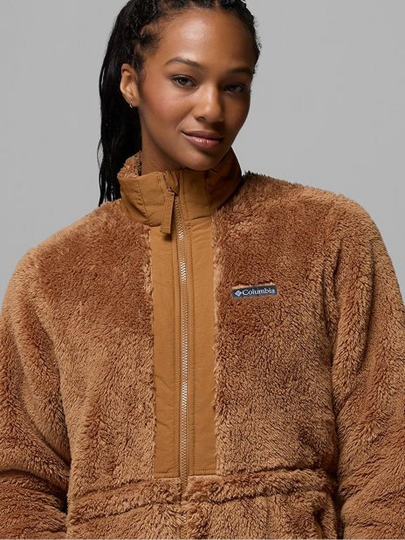 Woman wearing a camel-colored fleece jacket with front zipper and high collar.