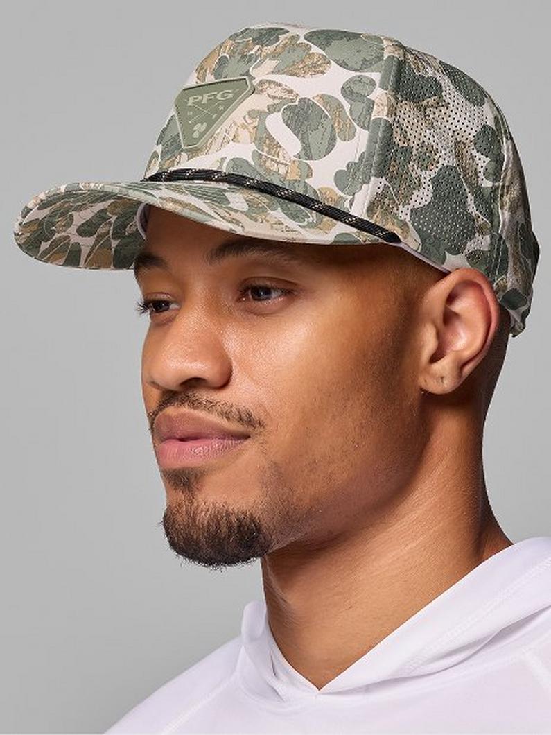 Man wearing a camouflage patterned baseball cap with mixed green and tan colors in profile view.
