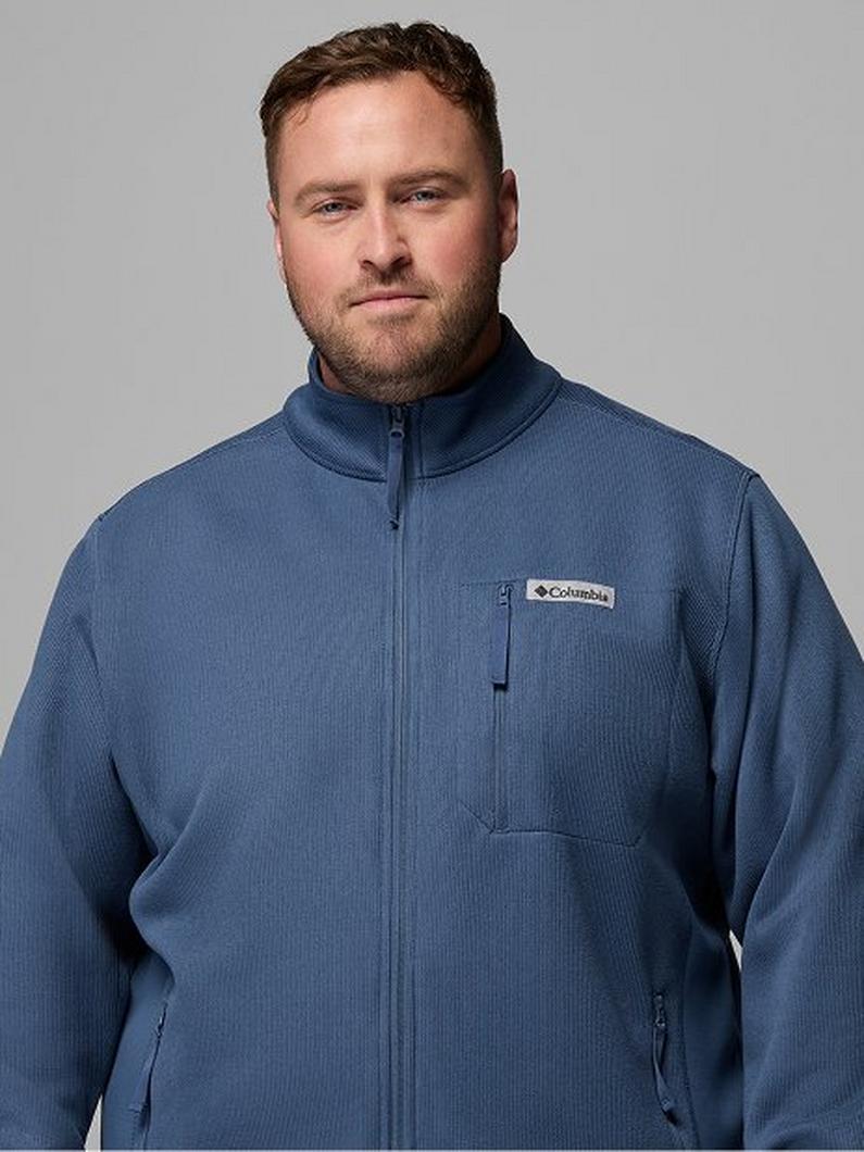 Man wearing a blue half-zip fleece pullover with high collar and chest pocket.