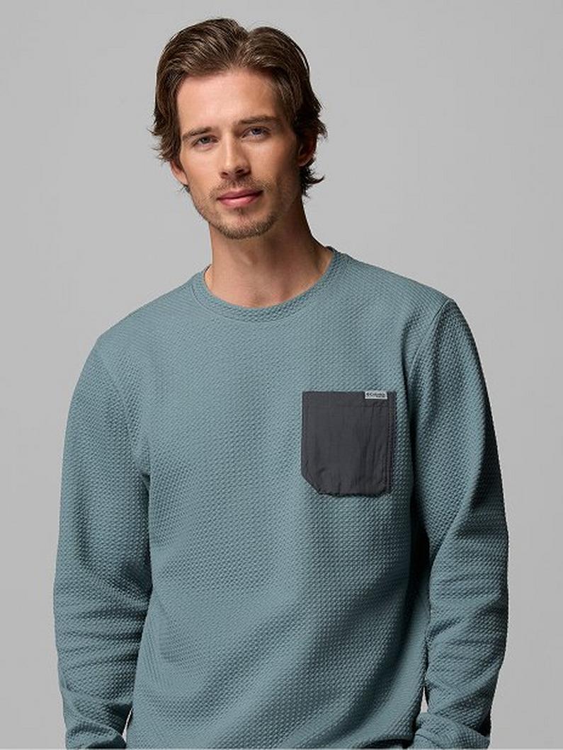 Man wearing teal textured long-sleeve crew neck shirt with contrasting dark chest pocket.
