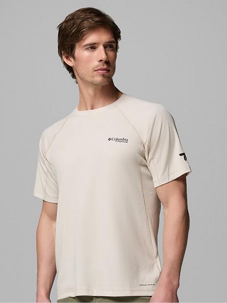 Man wearing a cream-colored short-sleeve athletic t-shirt with small chest logo.