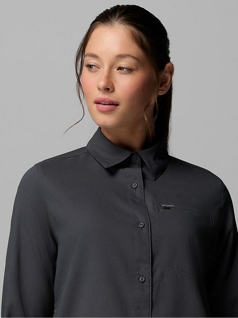 Woman wearing a dark gray button-up shirt with collar and chest pocket.