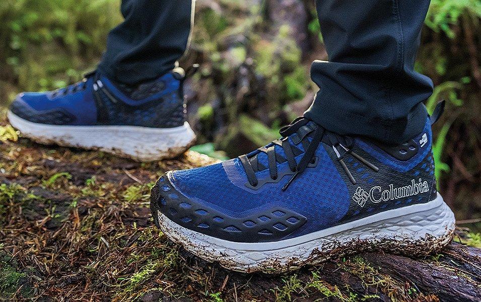 Une paire de pieds portant des chaussures de randonnée boueuses Columbia.
