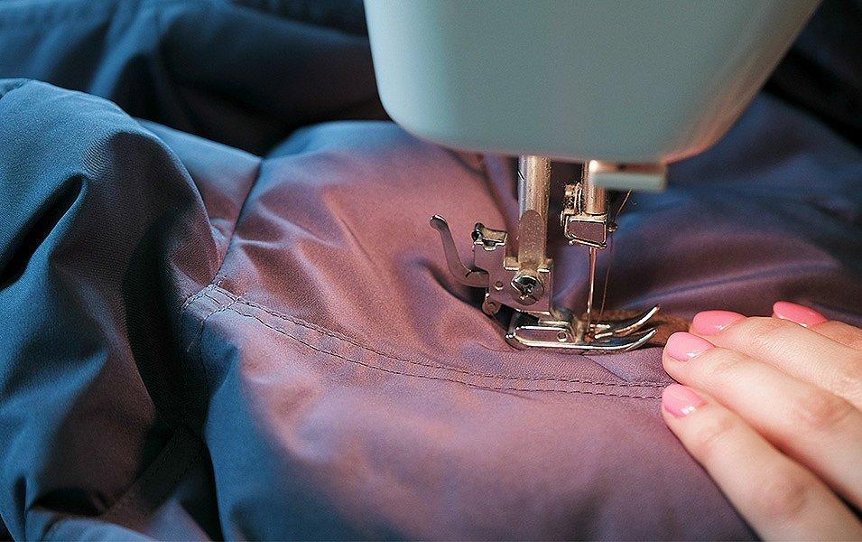 Coutures de veste réparées par une machine à coudre.