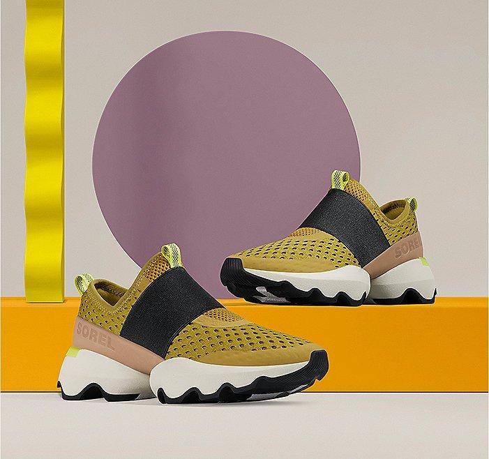 A pair of Kinetic Impact Strap sneakers on an orange background