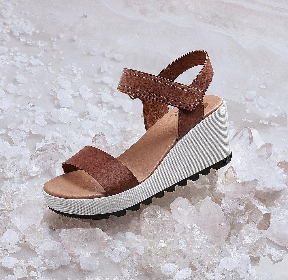 A Cameron Wedge sandal surrounded by white crystals.