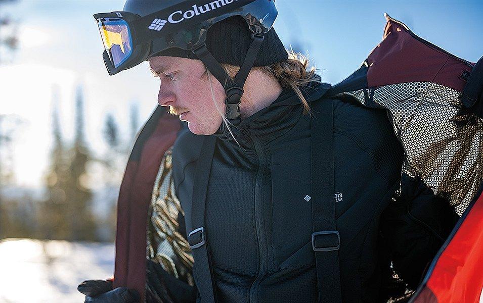 A person removing a Columbia Omni-Heat Infinity Jacket showing off the gold lining. 
