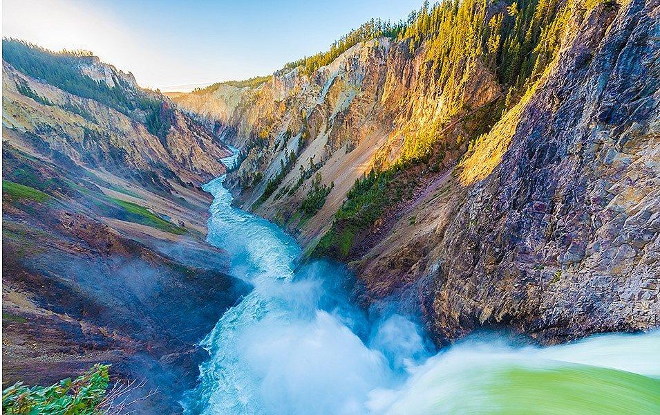 Rushing water from the perspective of a massive waterfall flowing through the Grand Canyon of Yellowstone National Park. 