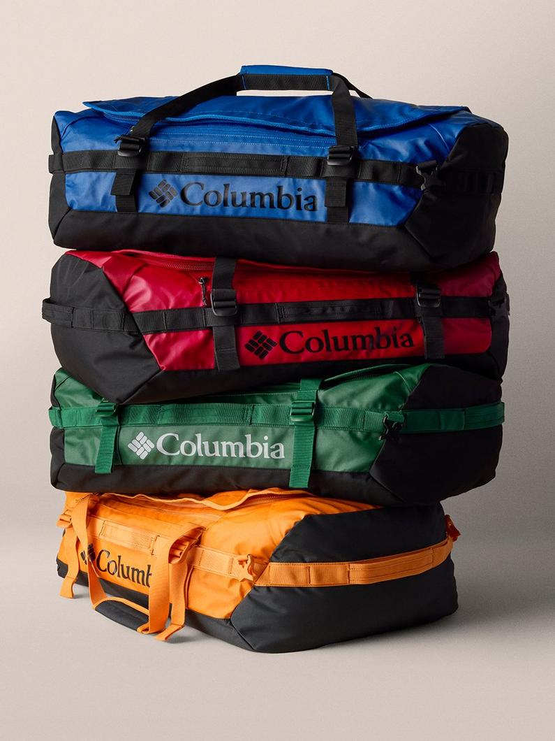 Stack of four duffel bags in blue, red, green, and orange with black accents and adjustable straps.