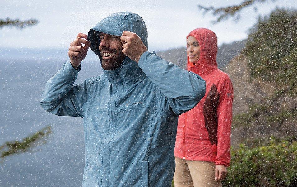 Deux personnes en randonnée sous la pluie portant des vêtements Columbia Sportswear.