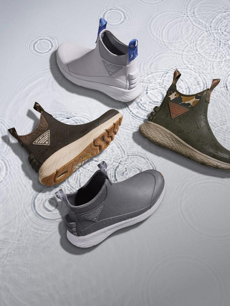 Four waterproof ankle boots displayed on wet surface with water ripples in white, gray, and olive green.