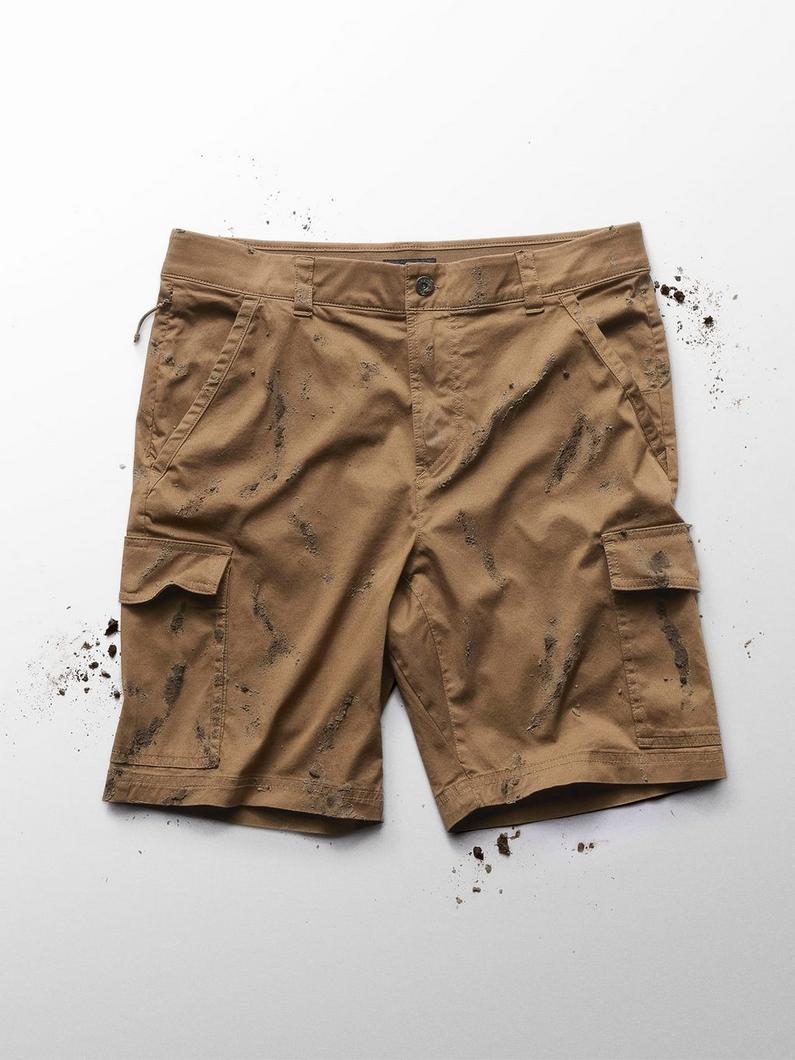 Tan cargo shorts with multiple pockets covered in dirt and mud stains.