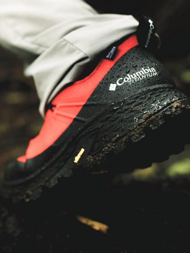 Close-up of black and red hiking boot with textured sole and Titanium technology label.