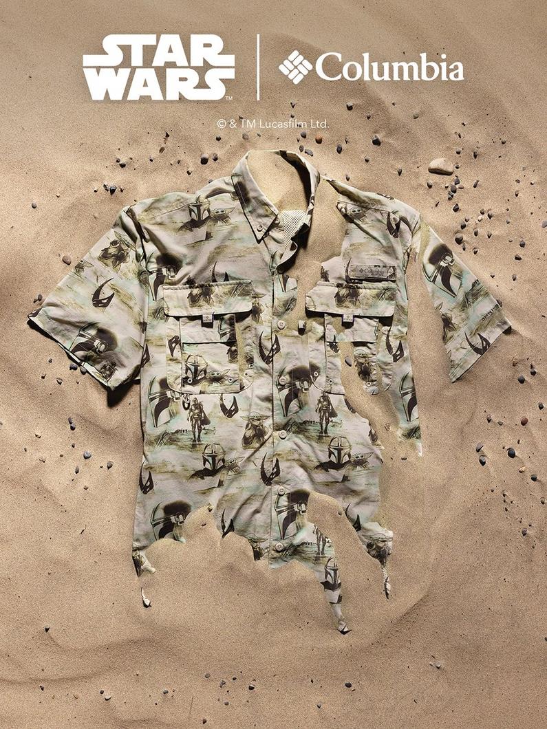 Fishing shirt with Star Wars character print pattern laying flat on sandy surface with scattered pebbles.