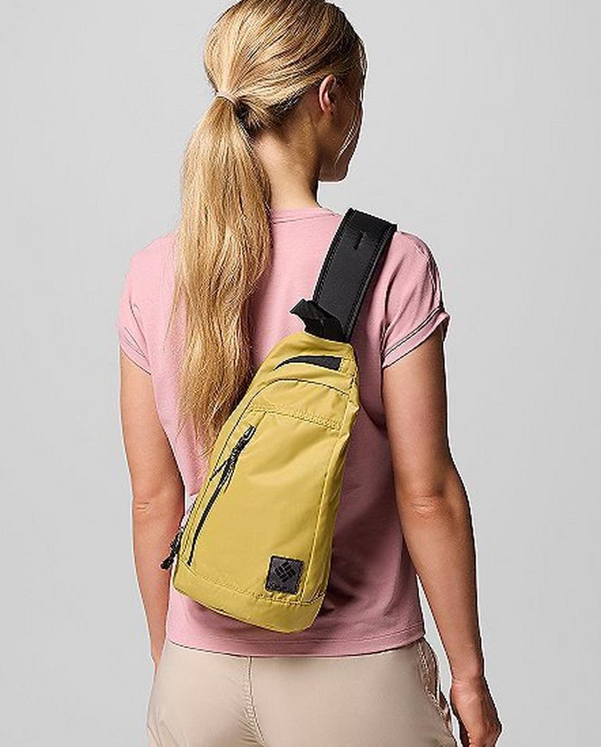 A woman faced away from the camera wearing a yellow cross-body bag.