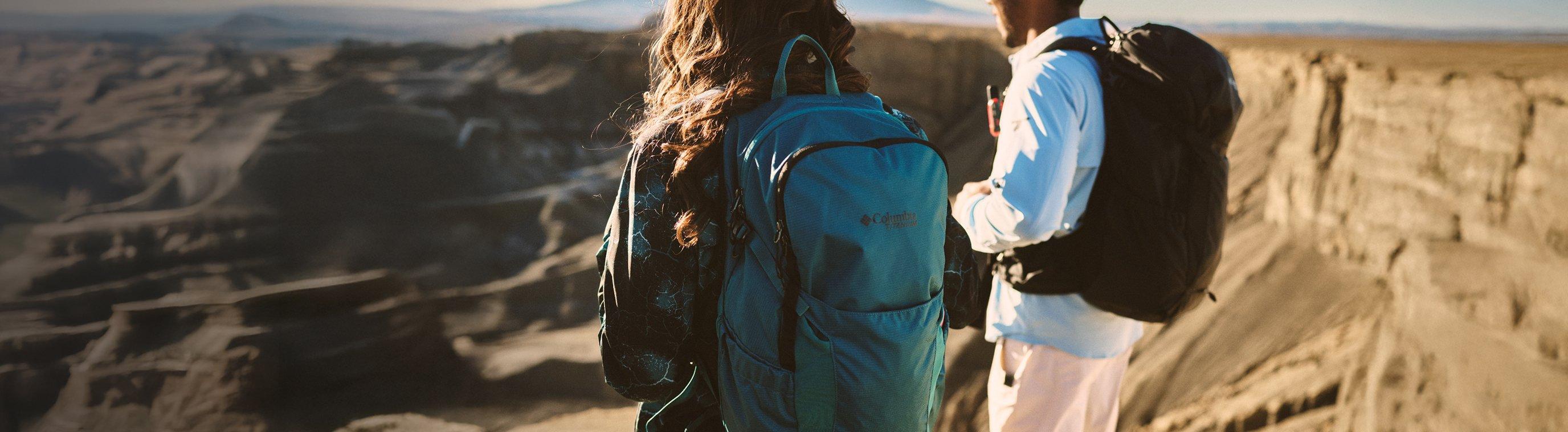Two hikers in a desert wearing backpacks