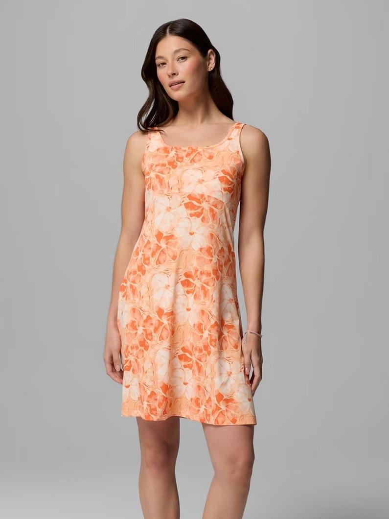 Woman wearing sleeveless A-line dress with orange and peach floral print pattern.