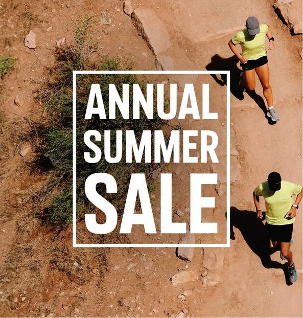 Aerial view of two people jogging on a dirt trail wearing yellow athletic shirts and black shorts.