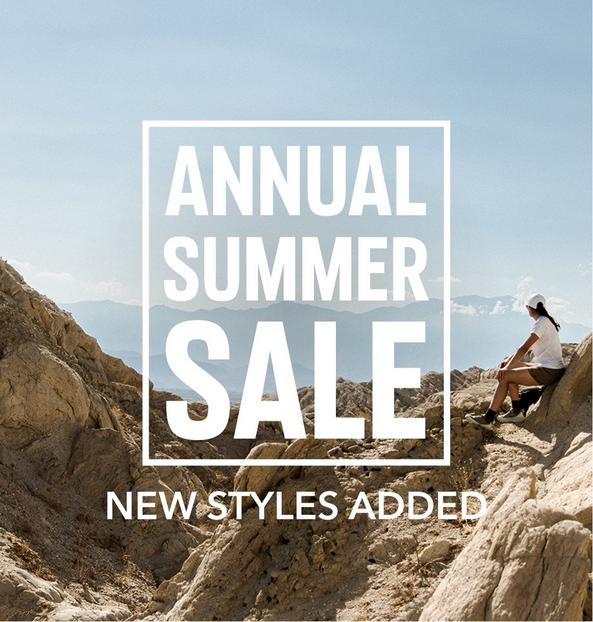 Woman sitting on rocky mountain terrain with text overlay reading ANNUAL SUMMER SALE.
