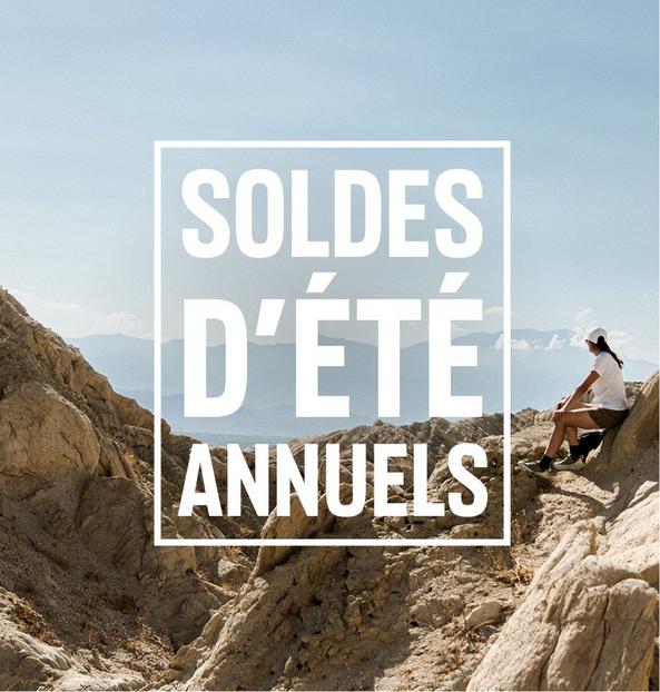 Person sitting on rocky mountain terrain with text overlay reading "SOLDES D'ÉTÉ ANNUELS".