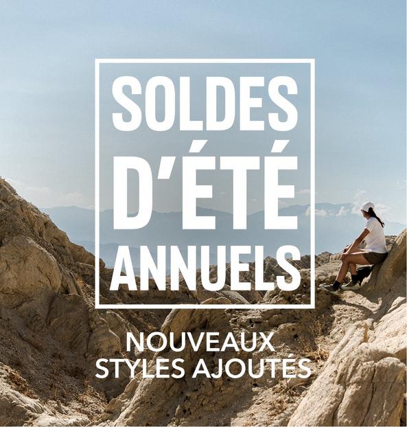 Woman sitting on rocky mountain terrain with text overlay advertising SOLDES D'ÉTÉ ANNUELS and NOUVEAUX STYLES AJOUTES.