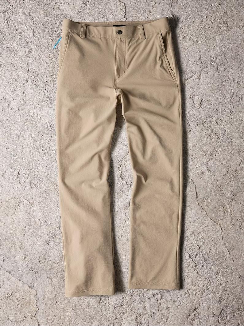 Beige chino pants with front pockets and button closure laid flat on textured surface.