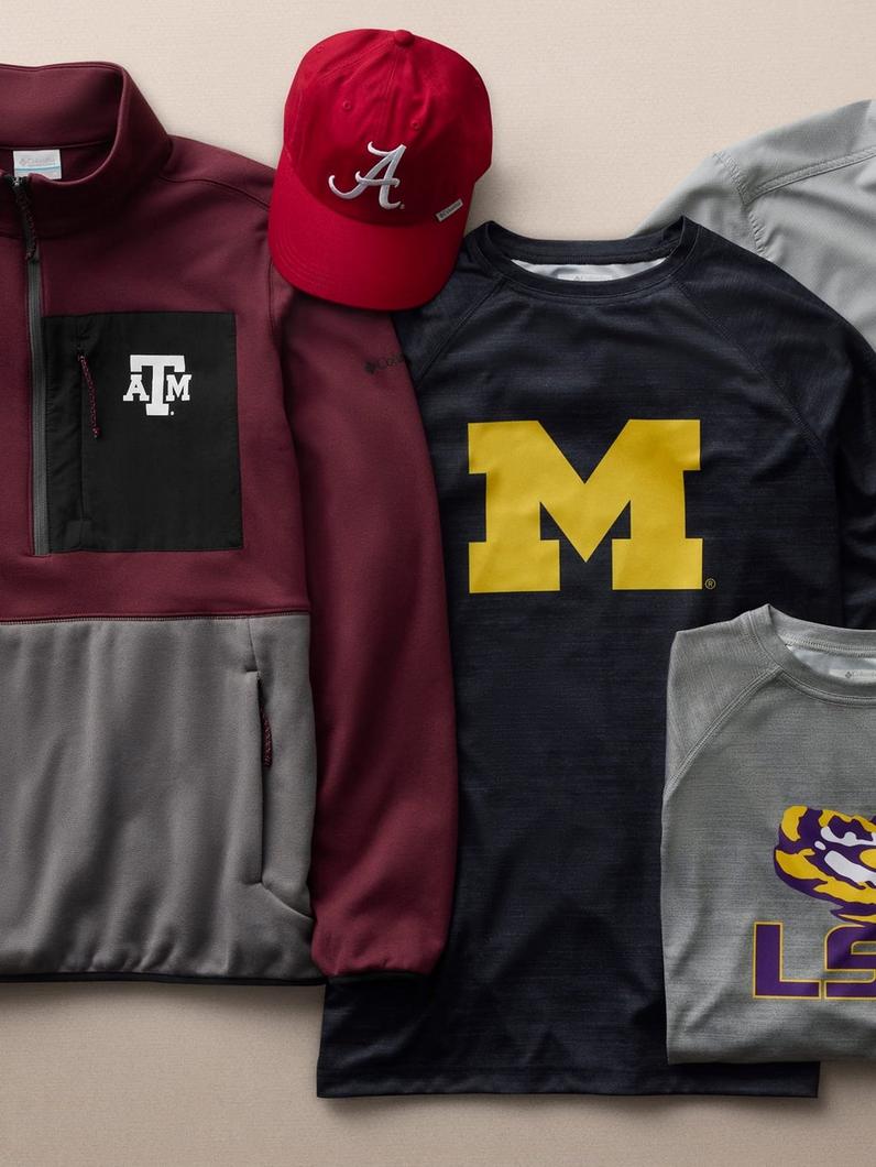 Flat lay of college athletic apparel including jacket, cap, and shirts with university logos.