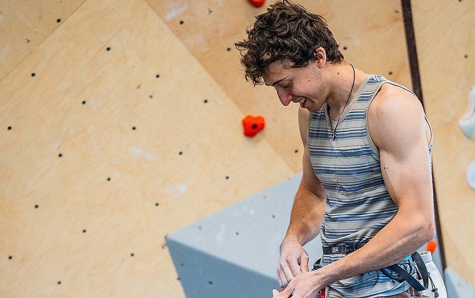US Climbing Team member/Olympic athlete, Jesse Grupper, tying a figure eight knot before climbing in an indoor gym. 