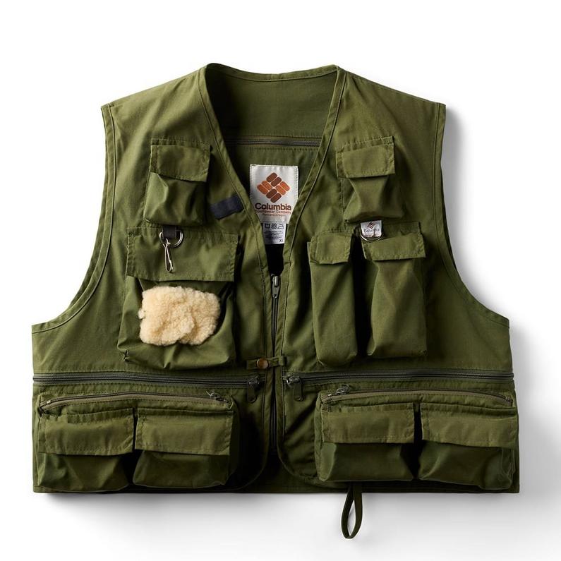 Olive green utility vest with multiple pockets, front zipper, and fuzzy patch attached to chest pocket.