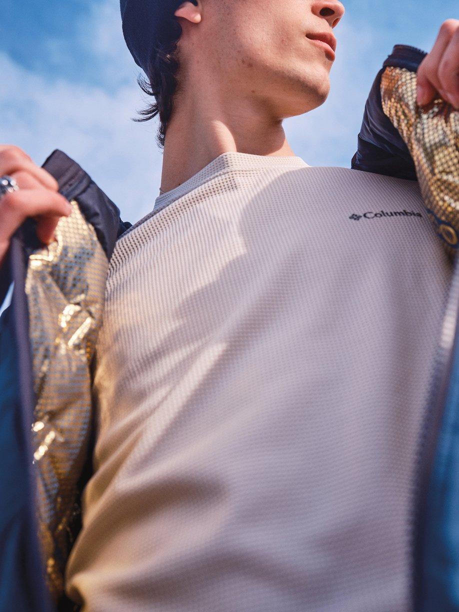Hiker opening warm jacket lined with gold dots.