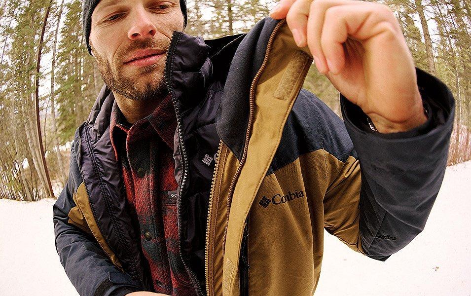 A man who isstanding the snow shows off his Columbia 3-in-1 Interchange Parka.