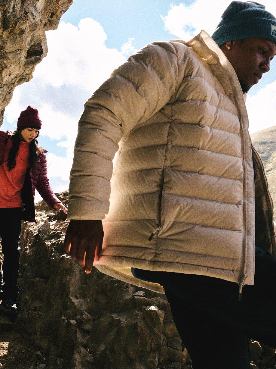 Fall New Arrivals with an image of people hiking through rocky terrain.