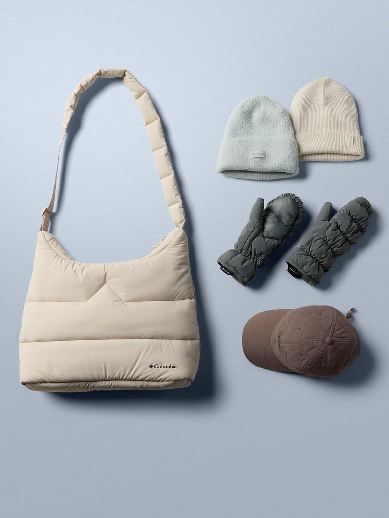 Beige quilted crossbody bag displayed with winter accessories including knit beanies, mittens, and a cap.