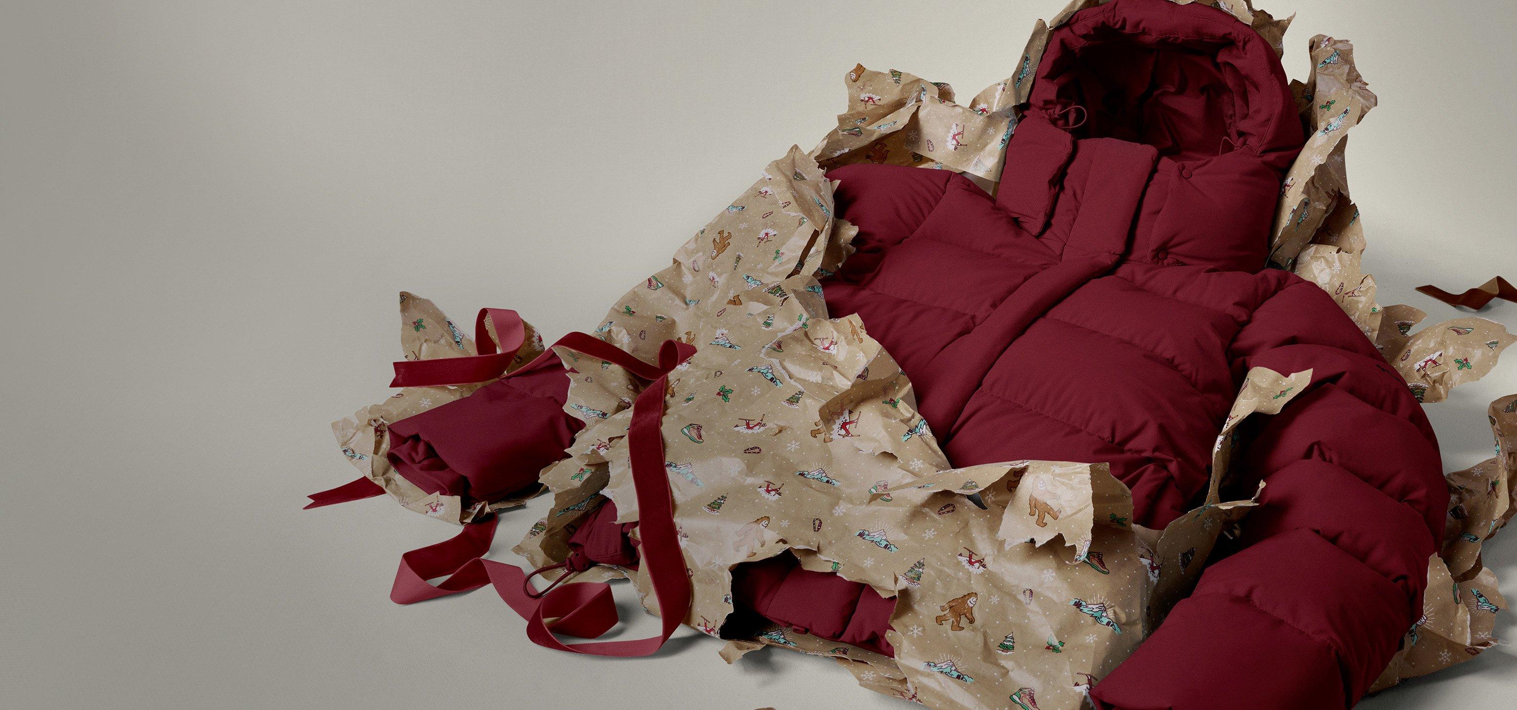 A blue puffer jacket busting out of turn up wrapping paper.